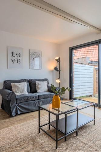 un salon avec un canapé et une table en verre dans l'établissement Maisonette 2 chambres avec cour, proche tram, à Mouvaux