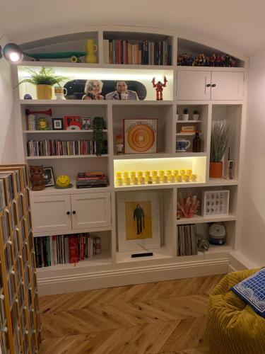 a room with a book shelf filled with books at The Coal Vaults in Brighton & Hove