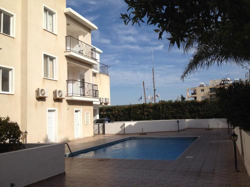 een zwembad voor een gebouw bij Laertis Complex in Paphos City