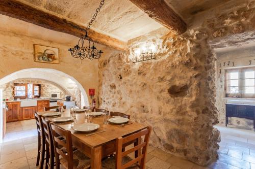a dining room with a table and a stone wall at Bebbuxija Pool Farmhouse Gozo - Happy Rentals in Xagħra