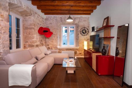 a living room with a couch and a tv at Sizgoric Palace Suites Sibenik in Šibenik