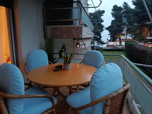 a table and chairs on a balcony with a table at Four Reasons Apts Kamena Vourla in Kamena Vourla