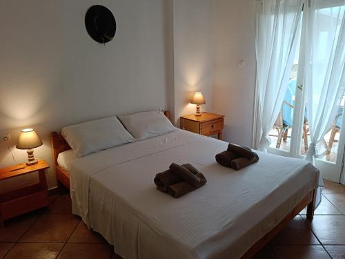 a bedroom with a bed with two brown towels on it at Four Reasons Apts Kamena Vourla in Kamena Vourla