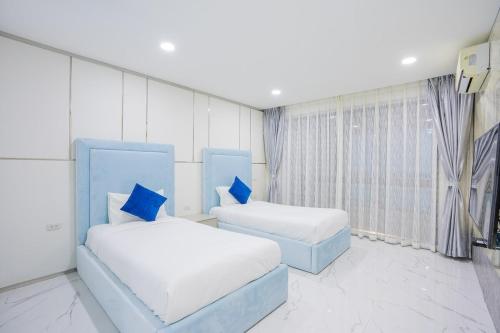 a room with two beds with blue pillows at My Havana, pool villa in Ban Nong Pru