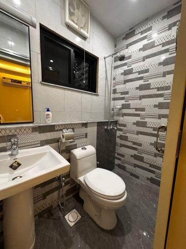 a bathroom with a toilet and a sink at Nova Plex Apartments in Jhelum