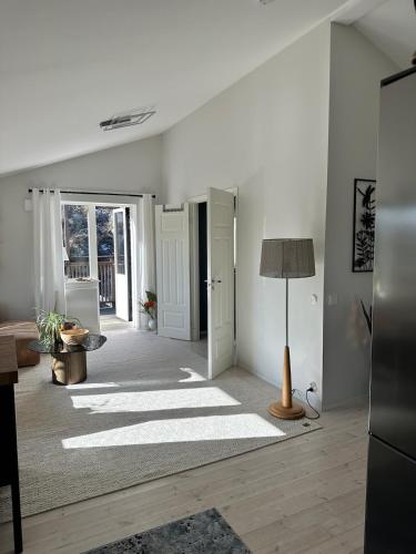 a living room with white walls and a lamp at Apartment close to central city in Gothenburg