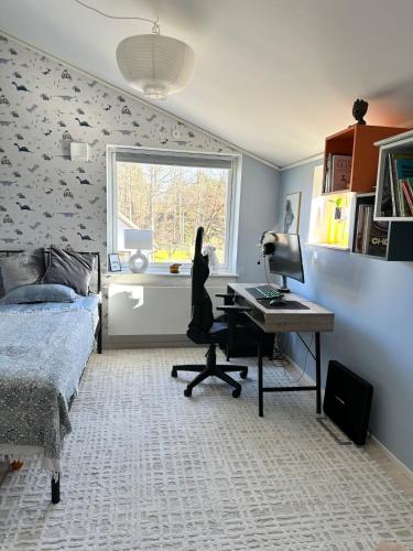 a bedroom with a bed and a desk and a window at Apartment close to central city in Gothenburg