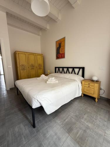 Un dormitorio con una gran cama blanca y un armario de madera. en Residenza Antinori, en LʼAquila