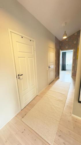 an empty room with a white door and a rug at Apartment close to central city in Gothenburg