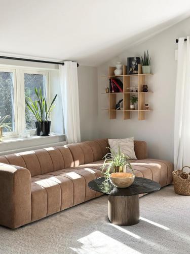 a living room with a brown couch and a table at Apartment close to central city in Gothenburg