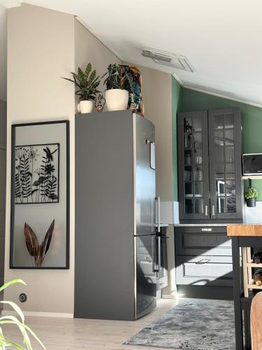 a kitchen with a refrigerator with plants on the wall at Apartment close to central city in Gothenburg