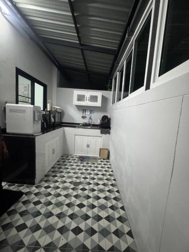 a kitchen with a black and white checkered floor at Sai's cozy house in Khanom