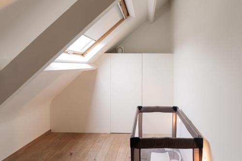 a staircase in a loft with a skylight at Casa Tintos in Sint-Amands
