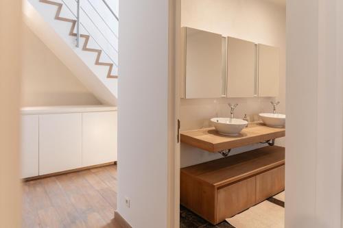 a bathroom with two sinks and a staircase at Casa Tintos in Sint-Amands