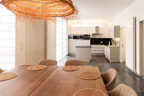 a kitchen and dining room with a wooden table and chairs at Casa Tintos in Sint-Amands