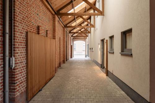an alley with a brick wall and a wooden ceiling at Casa Tintos in Sint-Amands