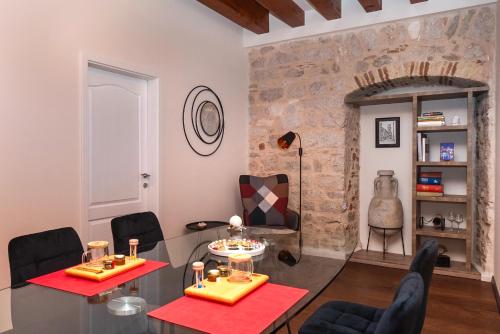 a living room with a glass table and chairs at Sizgoric Palace Suites Sibenik in Šibenik