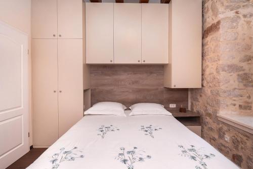 a bedroom with a bed with white cabinets at Sizgoric Palace Suites Sibenik in Šibenik