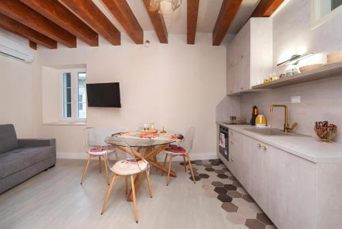 a kitchen with a table and chairs in a room at Sizgoric Palace Suites Sibenik in Šibenik