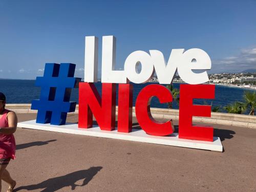 a woman walking in front of a sign that reads love nm at Wunderschöne Wohnung in Jugendstilvilla am Hafen in Nice