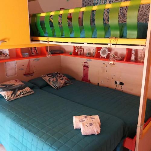 a small bed in a room with a green bedsheet at IL FARO Comfort a 500 m dal mare in Casa Borgorosso