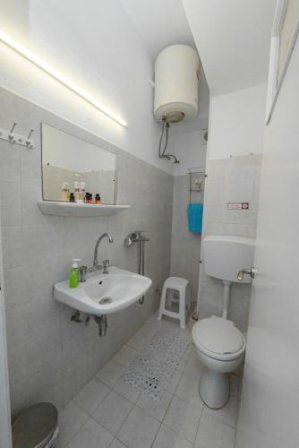 a bathroom with a sink and a toilet and a mirror at Panormos View in Nisída Planítis
