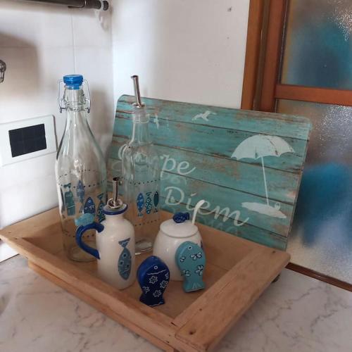 a wooden shelf with glass bottles on top of it at IL FARO Comfort a 500 m dal mare in Casa Borgorosso