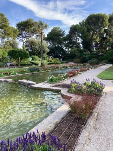 a pond in a park with flowers and trees at Wunderschöne Wohnung in Jugendstilvilla am Hafen in Nice