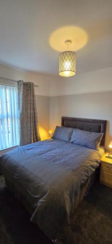 a bedroom with a large bed and a chandelier at Alexandra Park House in Belfast