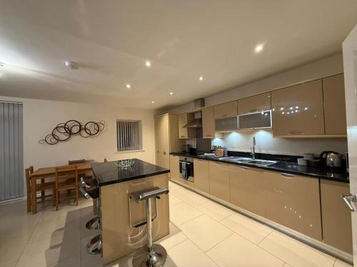 a kitchen with brown cabinets and a counter top at Solihull Centre Apartments in Solihull