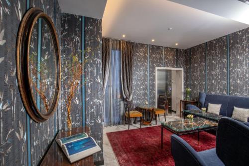 a living room with blue furniture and a mirror at The Inn at the Spanish Steps Luxury Collection - The Inn at the Spanish Steps in Rome