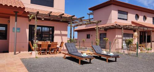 a patio with two chairs and a table in front of a house at Villa Macaronesia Lajares Fuerteventura Remote work in Majanicho