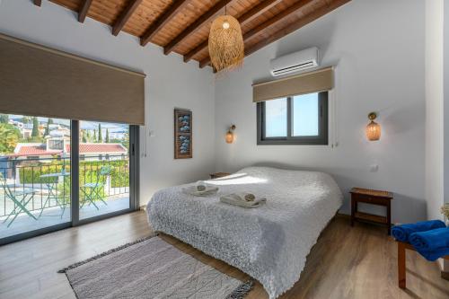 a bedroom with a bed and a large window at Villa Nomi in Peyia