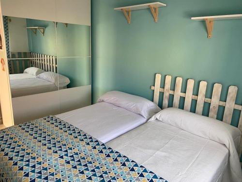 two twin beds in a room with a mirror at Casa rosa completa-patio- BBQ-columpios-buhardilla in Campillo de Altobuey