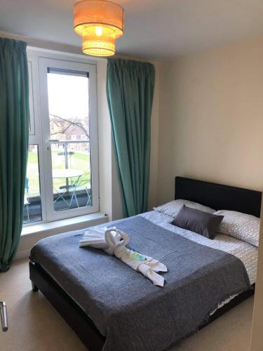 a bed in a bedroom with a large window at Solihull Centre Apartments in Solihull