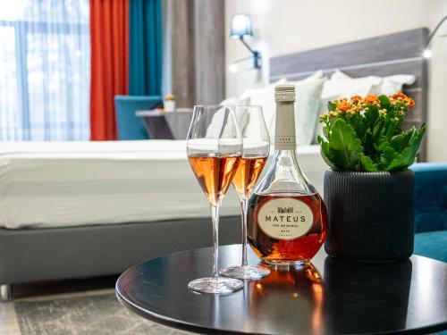 a bottle of wine and two glasses on a table at SPA Hotel Olymp in Velingrad