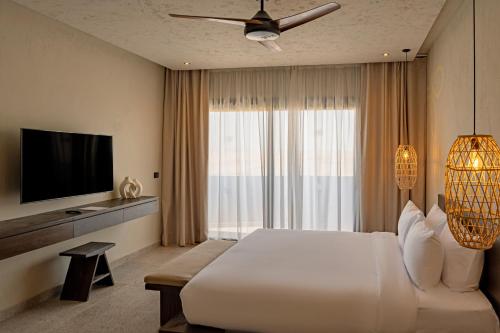 a bedroom with a large white bed and a television at Sentido Naga Bay - Adults friendly in Hurghada
