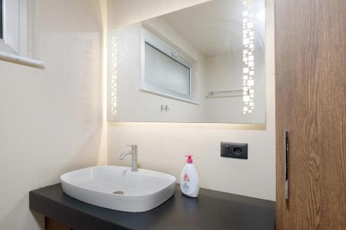 a bathroom with a white sink and a mirror at Gli Ulivi in Santo Stefano di Magra