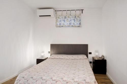 a bedroom with a bed and two tables and a window at Gli Ulivi in Santo Stefano di Magra