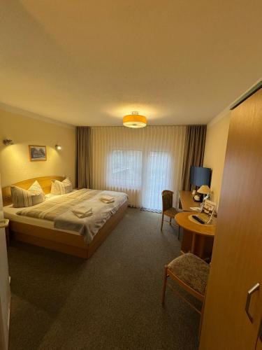 a hotel room with a bed and a desk at Haus Katharinensee in Müllrose