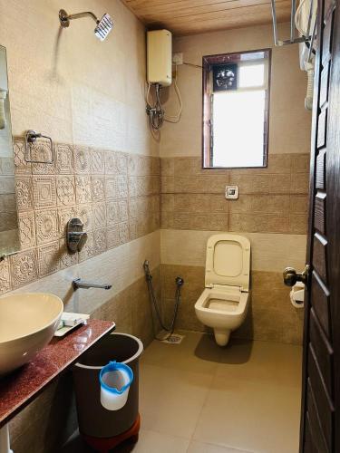 a bathroom with a toilet and a sink at Tipsy Spring Resort in Nagaon