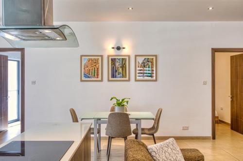 a kitchen and dining room with a table and chairs at Cozy Apartment minutes to seafront in Kalkara