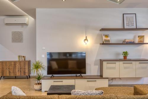 a living room with a large flat screen tv at Cozy Apartment minutes to seafront in Kalkara