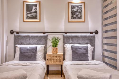 two beds sitting next to each other in a room at Cozy Apartment minutes to seafront in Kalkara