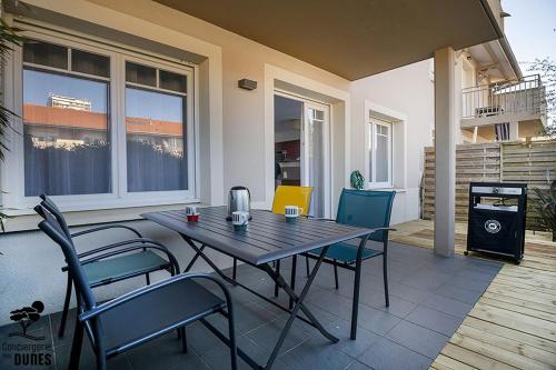 un patio avec une table et des chaises sur un porche dans l'établissement Great Studio, à Arcachon
