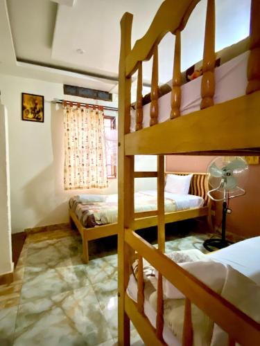 a bedroom with two bunk beds and a window at Gorilla African Guest House in Entebbe
