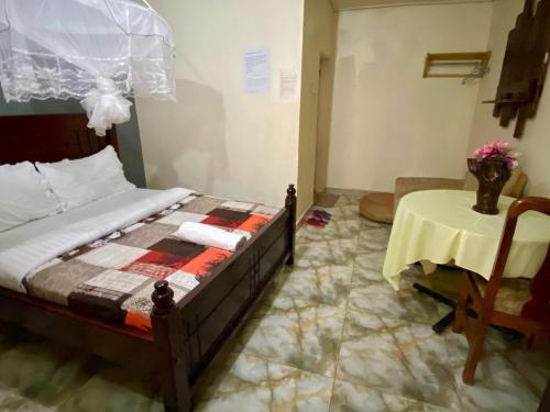 a bedroom with a bed and a table in a room at Gorilla African Guest House in Entebbe