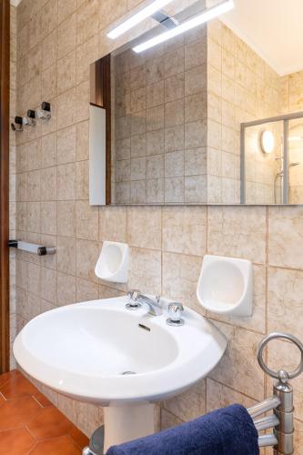 a bathroom with a white sink and a mirror at Exclusive Villa with Lake view-Private SPA in Galbiate
