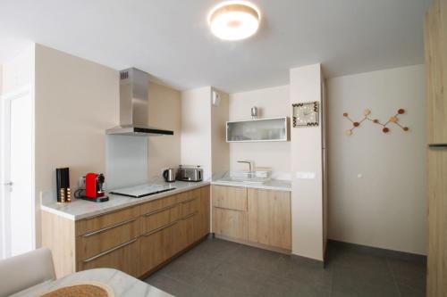 - une cuisine avec des placards en bois et un évier dans l'établissement New T3 with air conditioning 2 steps from the lake, à Aix-les-Bains