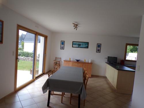 une cuisine et une salle à manger avec une table et des chaises dans l'établissement Erdeven Kerminihy Maison 6 personnes, à Erdeven